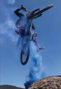 Ciclista en el aire con la bicicleta, entre humo azul.